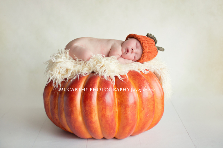 10 day old baby posed on a pumpkin